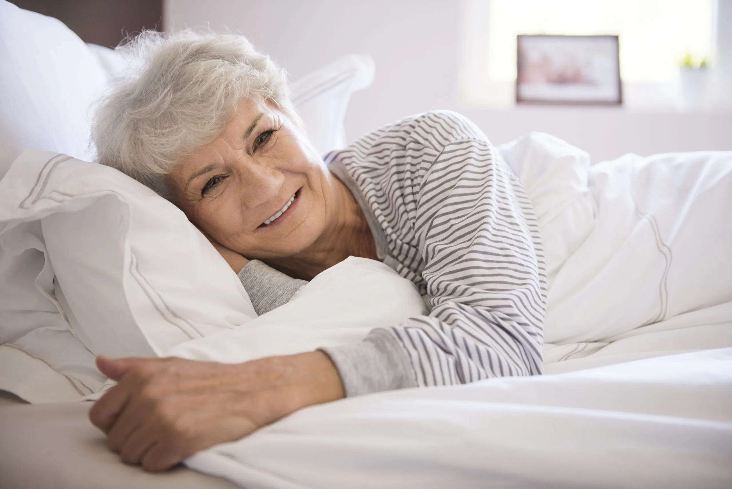 older lady lying in a very comfortble bed