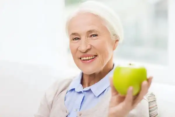 Senior woman eating an apple - Nutrition and Hydration training course