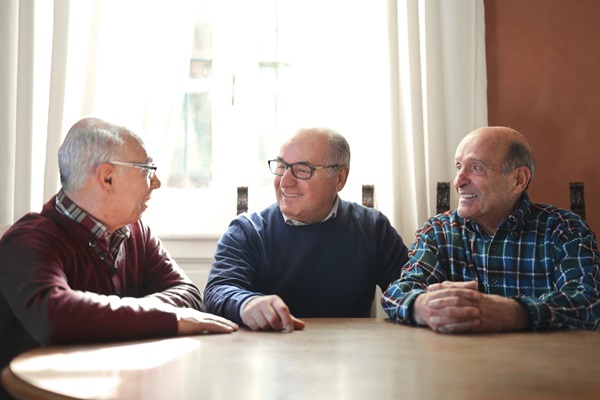 Older men sitting around a table talking - Cognitive Stimulation Therapy (CST) Facilitator Training Course