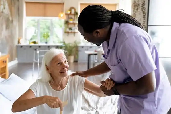 social-worker taking care of an older woman - Moving and assisting Refresher training course