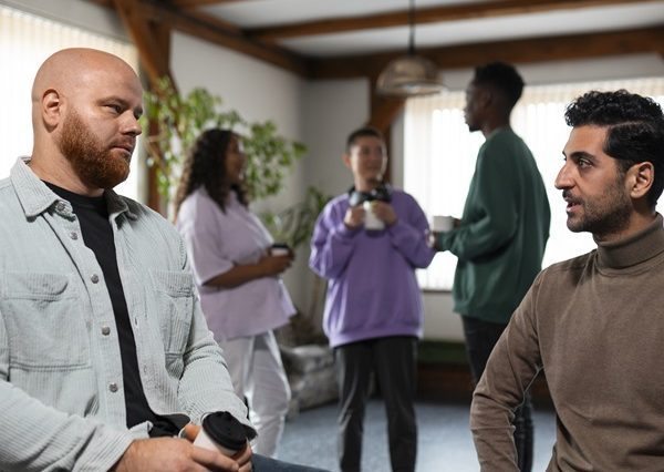 Two people in a discussion in an supportive group environment. Picture for Level 3 Safeguarding Adults training course.