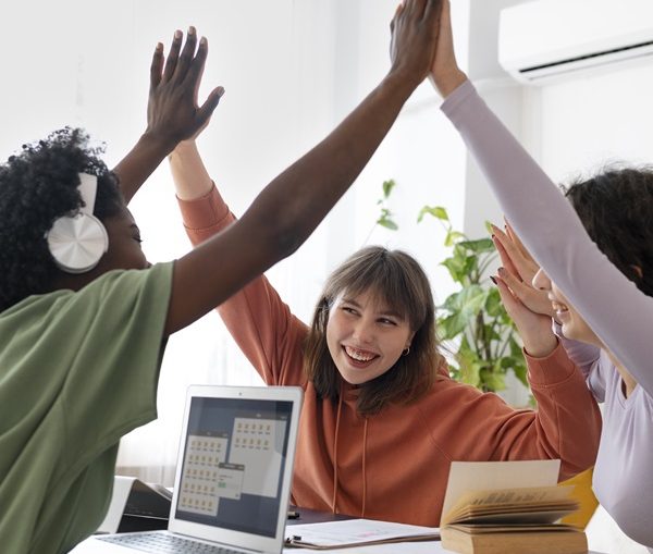 group of people high fiving and smiling - positive behaviour support training course