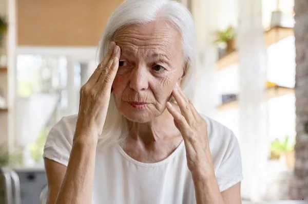 older lady holding forehead and cheek looking concerned - stroke awareness training