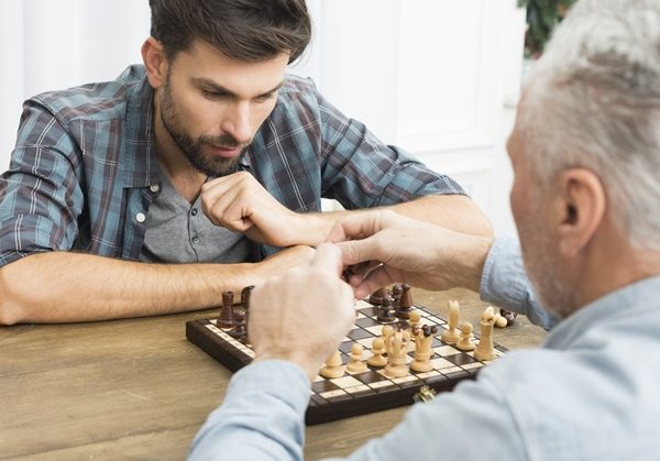 two men playing chess - distracting person by doing something they enjoy - supporting people in distress training