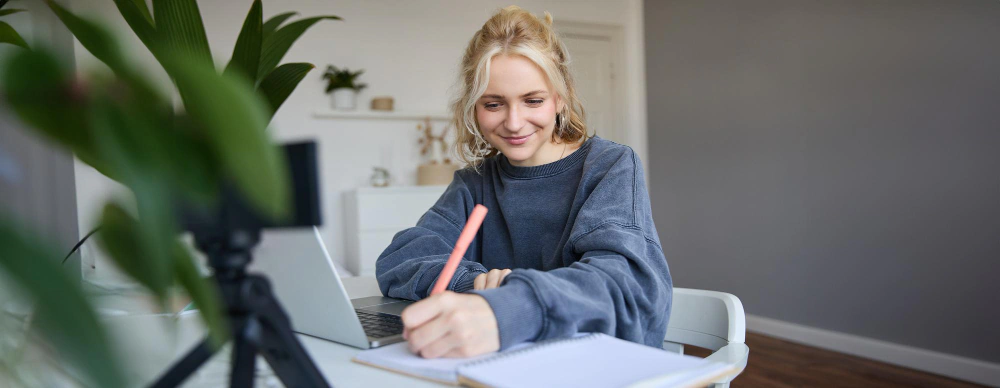 person studying at desk with laptop writing smiling academic writing workshop blog