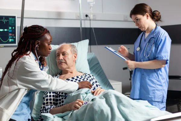 Doctor monitoring patient with nurse taking notes. Clinical Observations and National Early Warning Score (NEWS) course.