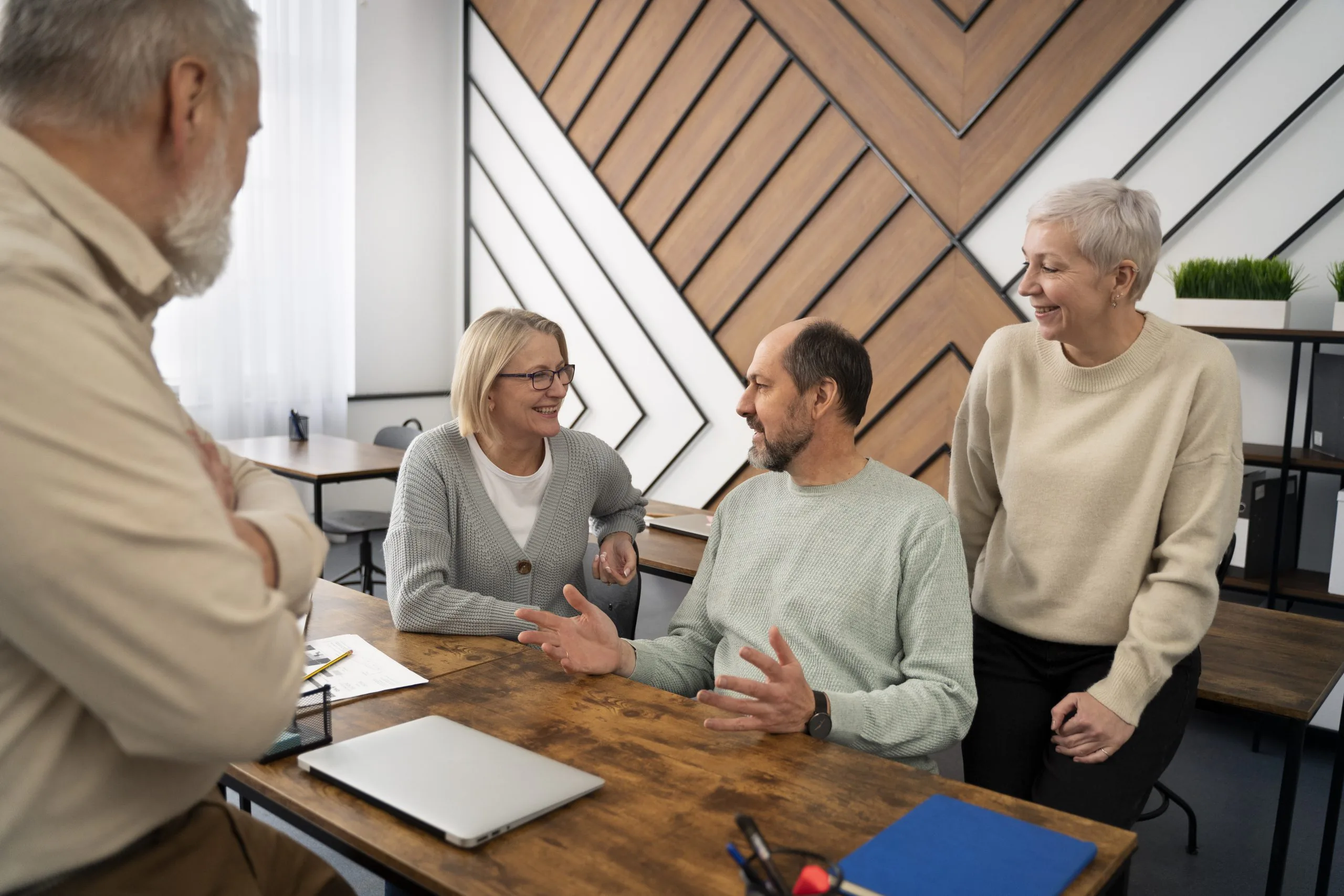 Group of older people sat round a table classroom communal room Cognitive Stimulation Therapy